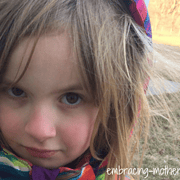 my five year old daughter outside wearing a winter coat and a serious look on her face